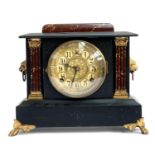 An ornate slate style clock, ebonised wood with marbled columns, manufactured by Wm. L Gilbert clock