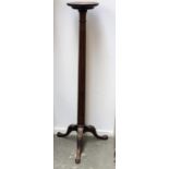 A mahogany tripod torchere with fluted column, on acanthus capped legs with claw and ball feet,