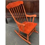 A orange stained rocking chair