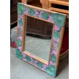 A carved wall mirror, the frame carved and painted with grape and vine decoration, 85x76cm