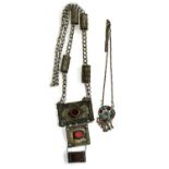 A Bedouin white metal hirz pendant (af), with three graduating panels set with red glass, the