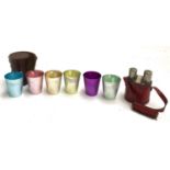 A set of 6 coloured metal stirrup cups, leather cased, together with 2 flasks, cards and dice in a