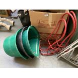 Three red metal saddle racks, together with three stable door feed buckets