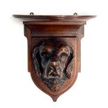 An oak wall bracket, well carved with the head of a foxhound, 30cm high