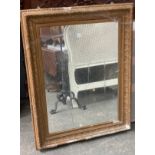 A large gilt gesso picture frame, as found, with mirrored plate