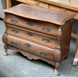A 20th century Dutch oak bombe chest of three drawers, with shaped top, on ball and claw feet,