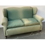 A two seater wingback sofa upholstered in a green fabric, 150cmW