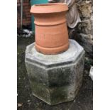 An octagonal composite stone plinth, 49cmW x 39cmH, together with a terracotta chimney pot