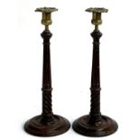 A pair of late 19th century mahogany candlesticks, with removable nozzles, of slender tapering form,