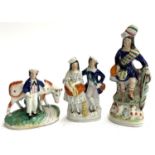 Three Staffordshire flatbacks: boy with cow, courting couple, and a highlander, the tallest 27cmH (