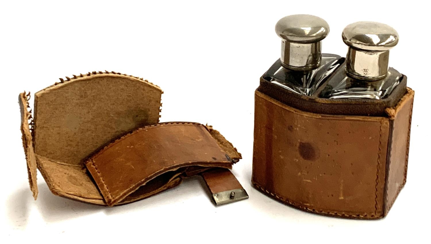 A leather cased set of two shaped glass spirit flasks, with nickel tops, the leather case AF, 11.