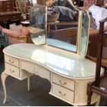 A white painted kidney shaped dressing table, with three part adjustable mirror above, 130cmW