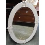 An oval wall mirror with bevelled glass and white painted metal frame, 92x67cm