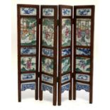 A Chinese four fold table screen, with painted porcelain panels depicting court scenes, etc (two