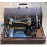 A Singer sewing machine, serial number v553594, in domed mahogany case