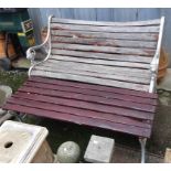 A slatted garden bench with cast metal ends with lion masks, 124cmW, together with a matching table