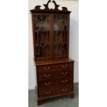 A 20th century mahogany glazed bookcase on a chest of four graduating drawers and bracket feet,