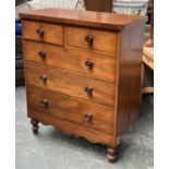 A Victorian mahogany chest of two short over three long drawers, on a shaped apron and turned