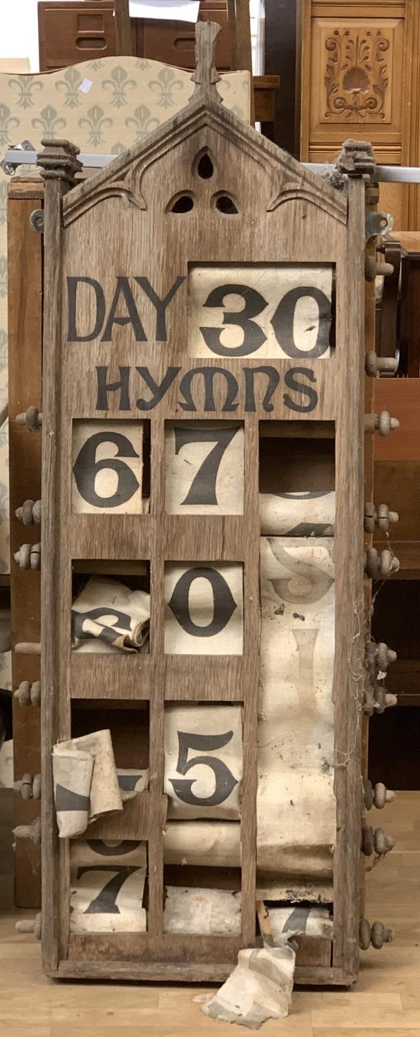 A Victorian oak Gothic revival hymn board with winding fabric reels, 94cmH