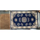 A small blue ground wool rug, 155x100cm, together with a coir doormat