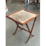 A converting oak framed occasional table/fire screen, with glazed embroidered panel with floral deco