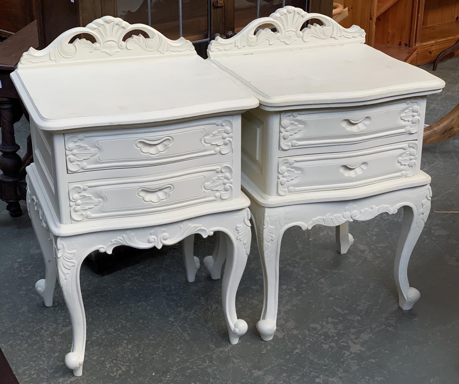 A pair of white painted bedside cabinets, each with two drawers on cabriole legs, 51x44x66cm