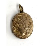 A gold back and front locket with engraved foliate design, approx. 2.5cmL