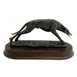 A resin figure of a coursing greyhound, the plinth 32cm long