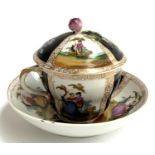 A continental porcelain cup and cover with matching saucer, the cup with encrusted rose finial,