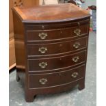 A Georgian style bowfront chest of drawers, with brushing slide over four graduating drawers, on