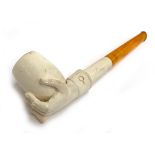 A Meerschaum pipe, in the form of a hand holding a bowl, with spare mouthpiece