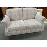 A Parker Knoll two seater sofa, upholstered in a cream and blue, 161cmW