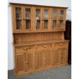 A pine kitchen dresser, six door glazed top, over a base of three drawers and a further six cupboard