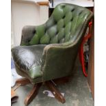 A green leather button back swivel chair, with repairs