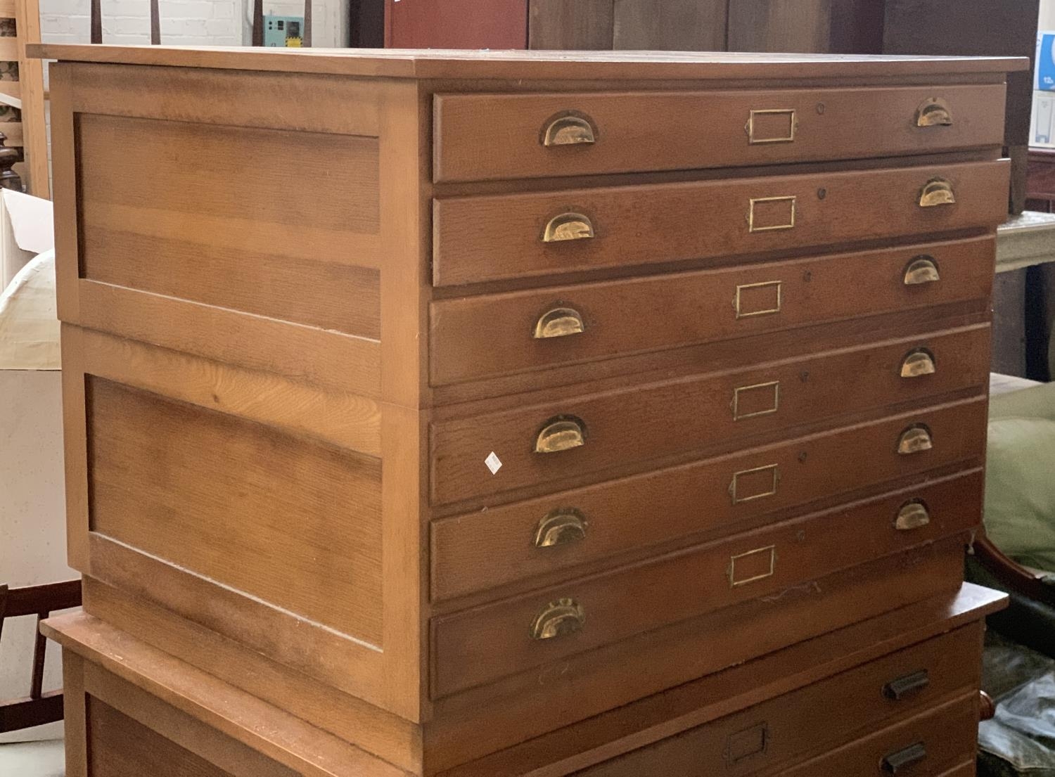 A 20th century oak six drawer plan chest, in two parts (three including plinth), with brass handles,