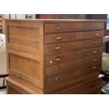 A 20th century oak six drawer plan chest, in two parts (three including plinth), with brass handles,