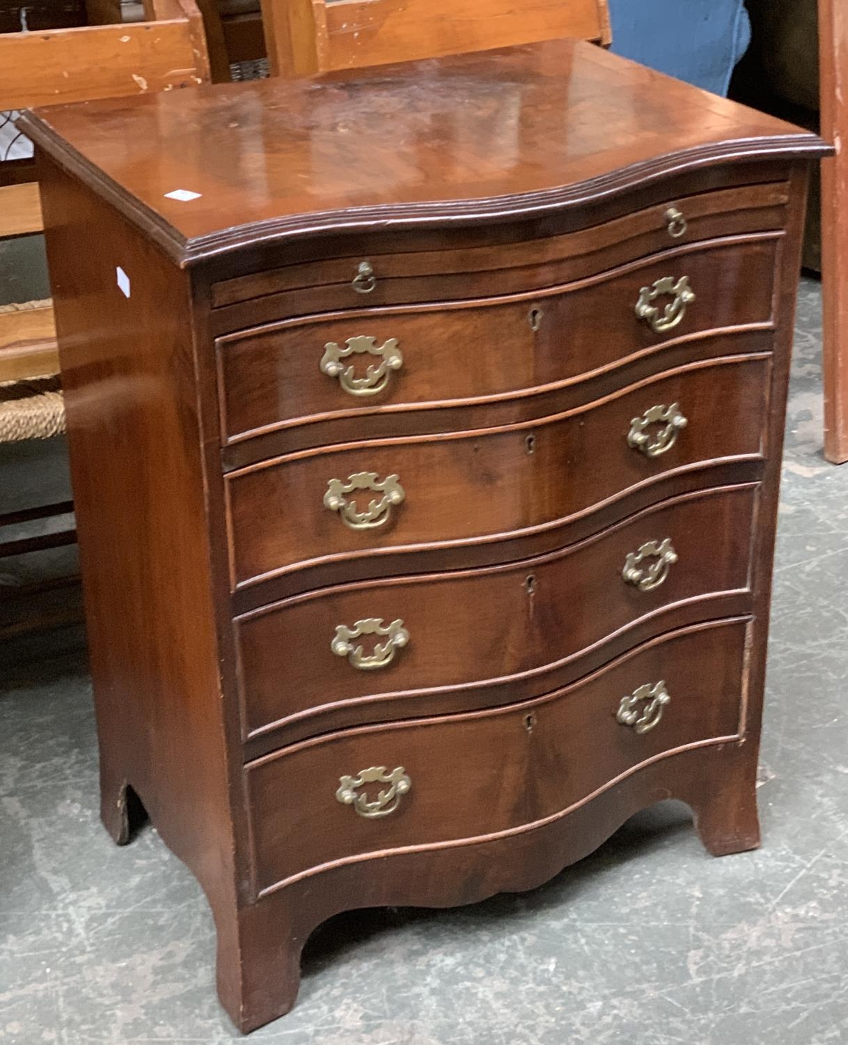 A Georgian style serpentine chest of drawers, slide over four graduating drawers, on bracket feet,