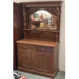 An early 20th century oak chiffonier with mirrored back flanked by turned supports, base with two
