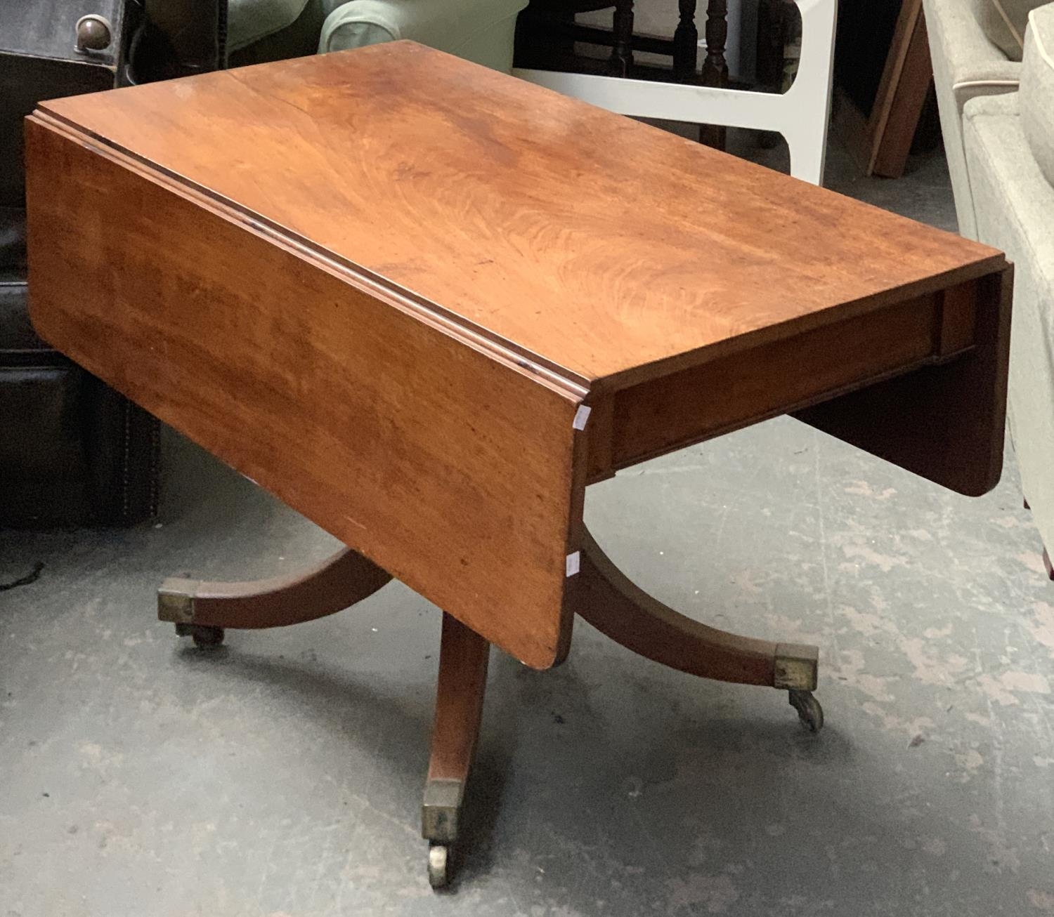 A Regency mahogany Pembroke table, on turned column, with swept legs and brass caps and casters,