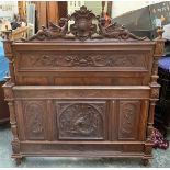 A carved hardwood double bed, the headboard crested with dragons