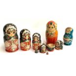 Three sets of Russian nesting matryoshka dolls, the tallest 24.5cmH