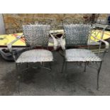 A pair of metal and wicker garden chairs