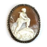 A late 19th/early 20th century carved shell cameo depicting a young man on a rocky outcrop, in a