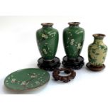 A pair of green cloisonne enamel vases with prunus design, each 16cmH, on carved hardwood stands;