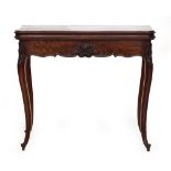 A French mahogany card table, pull out action, foldover shaped top with green baize lining, carved