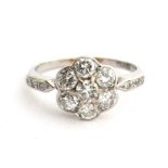 An Edwardian platinum and diamond floral cluster ring, six diamonds surrounding a central diamond,