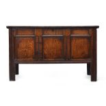 An 18th century and later three panel oak coffer, carved with initials 'CH', with fitted candle box,