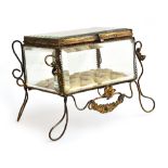 A 19th century French gilt metal mounted glass casket, on raised wire legs with floral decoration,
