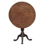 A George III mahogany circular tripod table, top top birdcage action, on turned column and