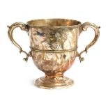 A large silver trophy cup, twin acanthus capped handles, engraved with a crest, on spreading